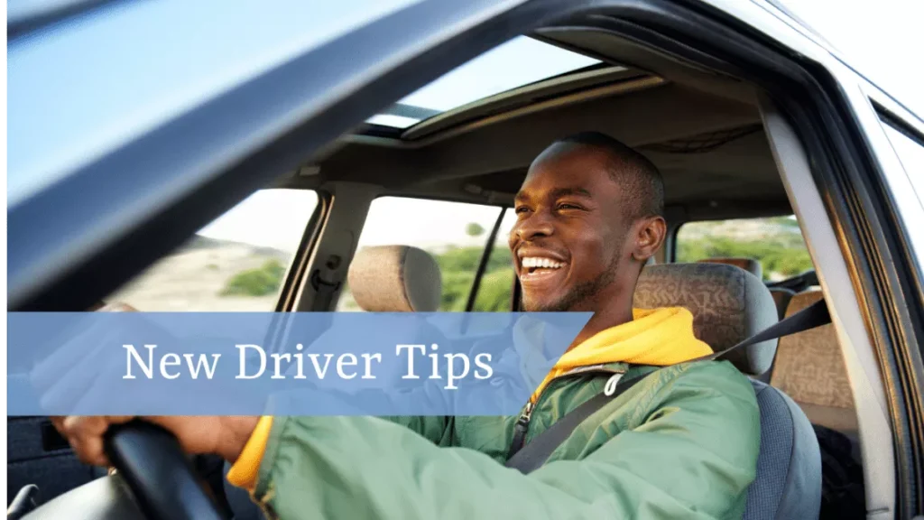 Man driving car, windows down and smiling.