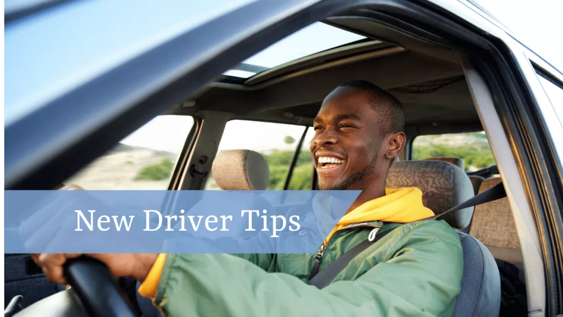 Man driving car, windows down and smiling.